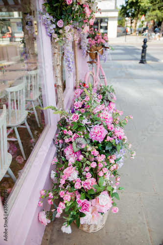 Photography Portrait View of Artificial Flowers Outside the Window of a Pink Cake Shop