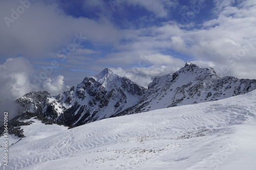 Aussicht auf die österreichischen Alpen mit Schnee im Sonnenlicht und Wolken © Rudolf