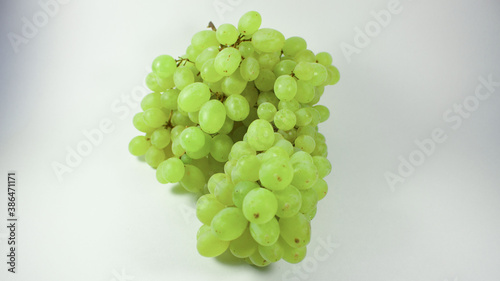 Bunch of green grapes on white background. One bunch of ripe organic green grapes isolated on white background, side view.