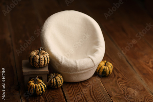Newborn photography backdrop digital props.  Armchair decorated with small pumpkins on a wooden background. 