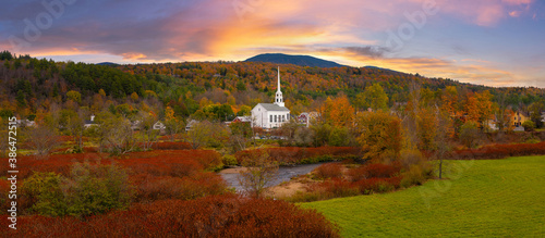 Panorama of Stowe Church in Vermont surrounded by the beautiful fall foliage photo