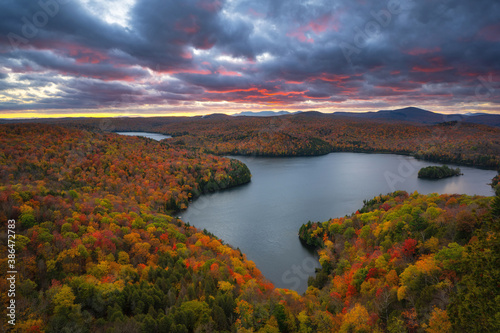 Colorful storm clouds over Nichols Pond surrounded by beautiful autumn colors in Vermont 