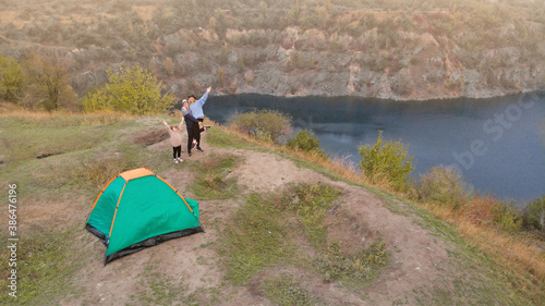 Aerial top view of family in campsite from above  parents and kid relax and have fun near mountains lake  family camp vacation