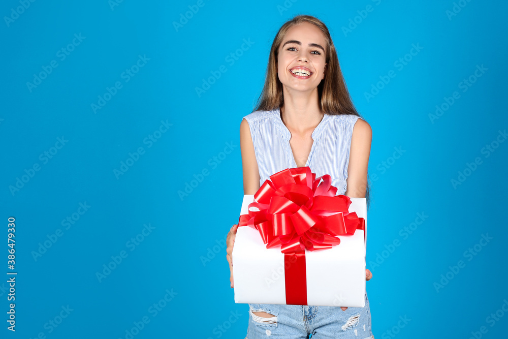 Young girl holding gift box on blue background Young girl holding gift box on blue background