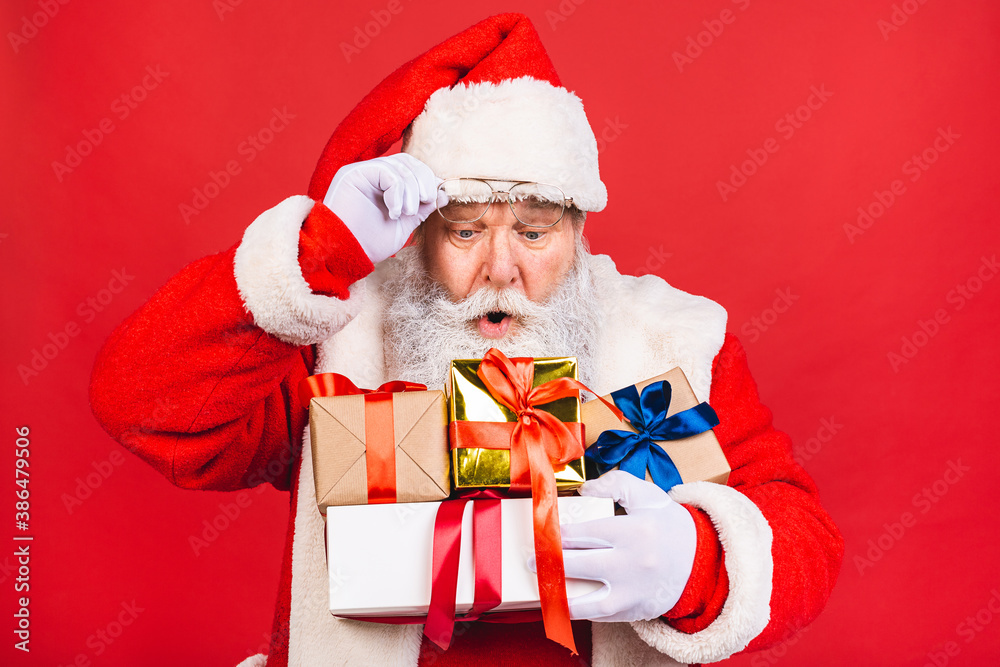 Photo of happy Santa Claus with present gift boxes lsolated over red background. Christmas and New Year concept. Photo of happy Santa Claus with present gift boxes lsolated over red background. Christmas and New Year concept.