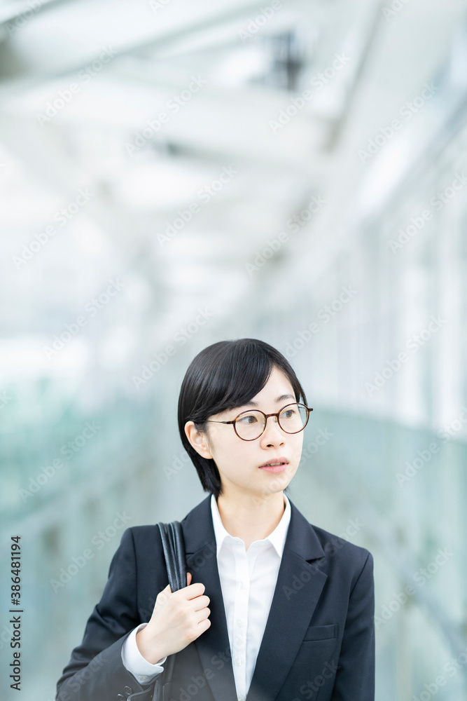 スーツを着て、緊張した表情をしている若い女性