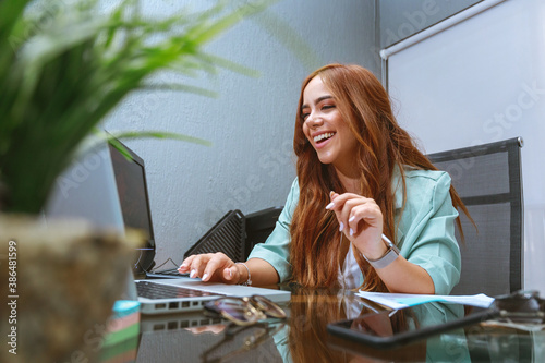 mujer joven empresaria emprendimiento trabajando en escritorio oficina sonriente feliz realizada