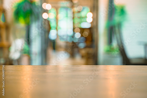 Soft focus background of wooden table and bokeh in cafe shop.