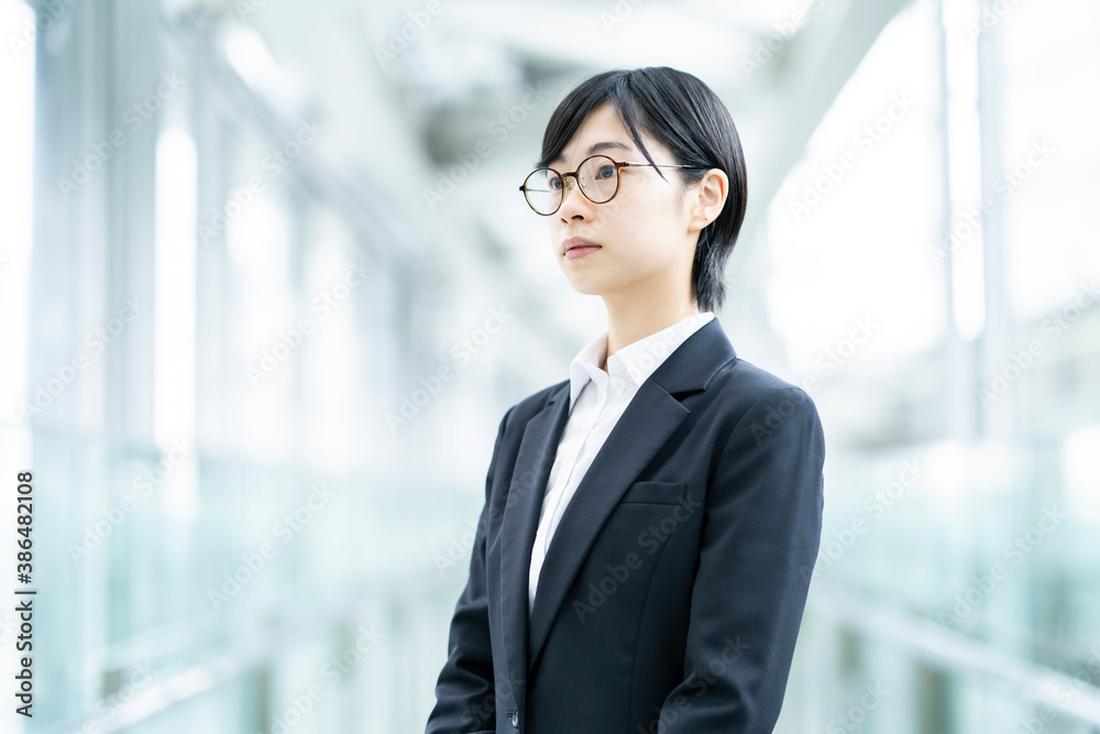 スーツを着て、緊張した表情をしている若い女性 スーツを着て、緊張した表情をしている若い女性