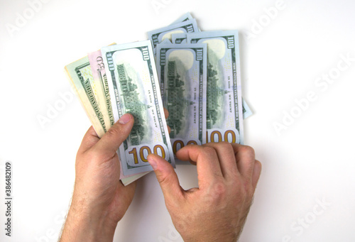Mens hands count money. Dollars on a white background.