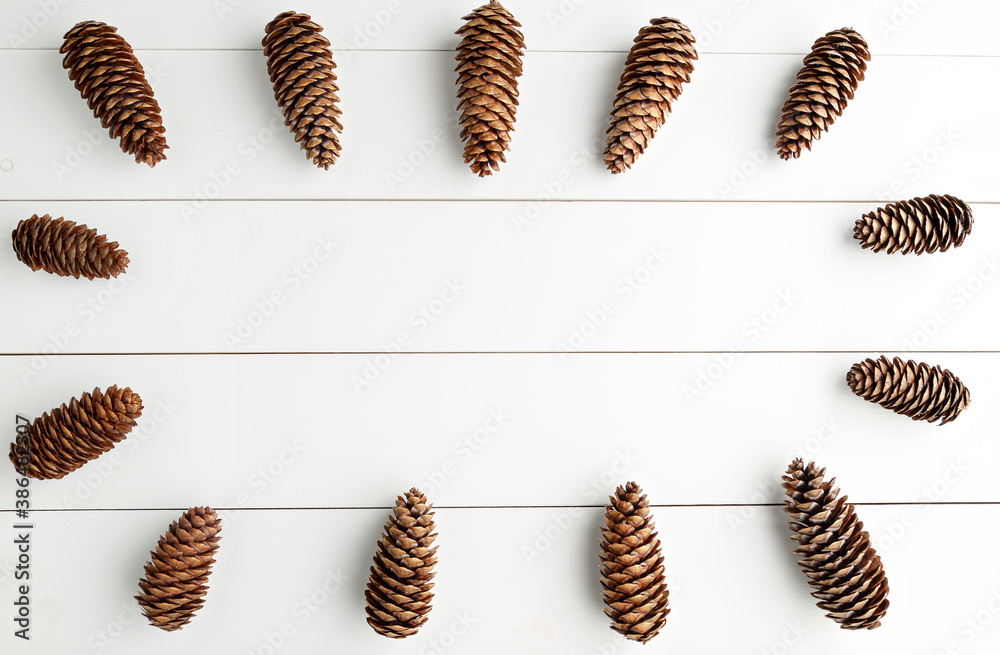 Frame of spruce cones on a white wooden background Frame of spruce cones on a white wooden background