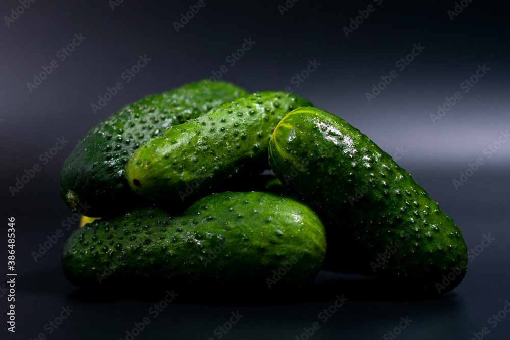 In the center of the screen, a closeup image shows a pile of fresh green cucumbers. In the center of the screen, a closeup image shows a pile of fresh green cucumbers.