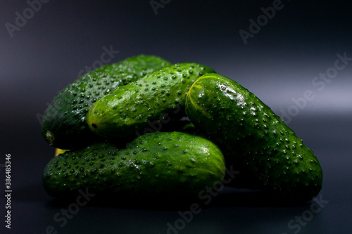 In the center of the screen  a closeup image shows a pile of fresh green cucumbers.