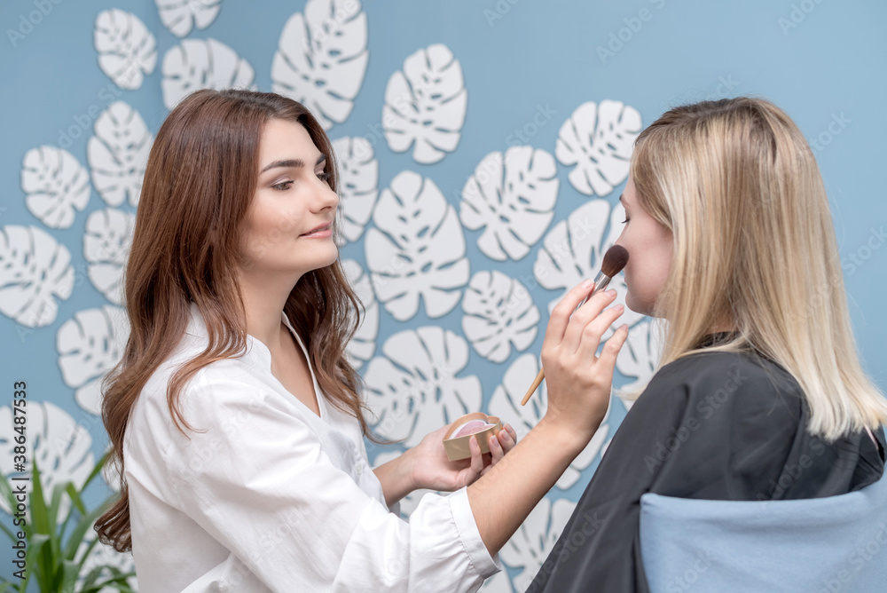 Professional makeup artist does glamorous model makeup at work. Young girl Professional makeup artist does glamorous model makeup at work. Young girl