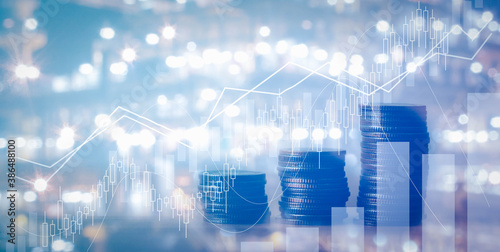 Close up of stacking of growth up coins with Double exposure of chart graph and night shift of oil and gas platform for finance and business ,capital banking and investment concept. © osabee