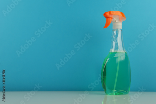 spray bottle on blue background with copy space