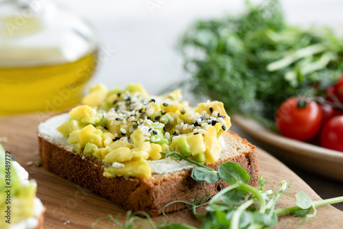 Bread toast with avocado, cream cheese and sesame seeds. Healthy breakfast or snack food