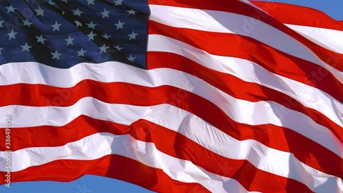 Wallpaper Mural American flag of the USA flutters in the wind against a clear blue sky on a sunny day. Close Up, 4K video Torontodigital.ca