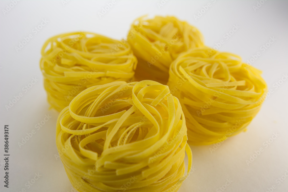 Yellow pasta fettucine on a white background. Yellow pasta fettucine on a white background.
