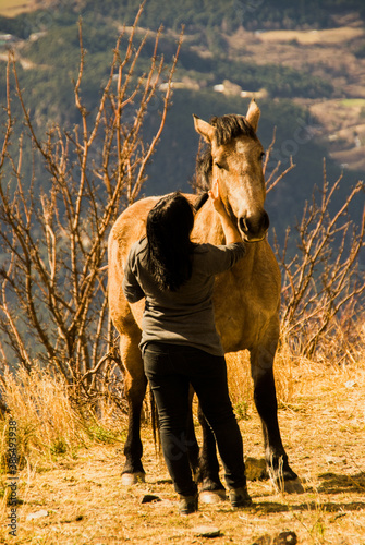 woman standing by a beautiful horse