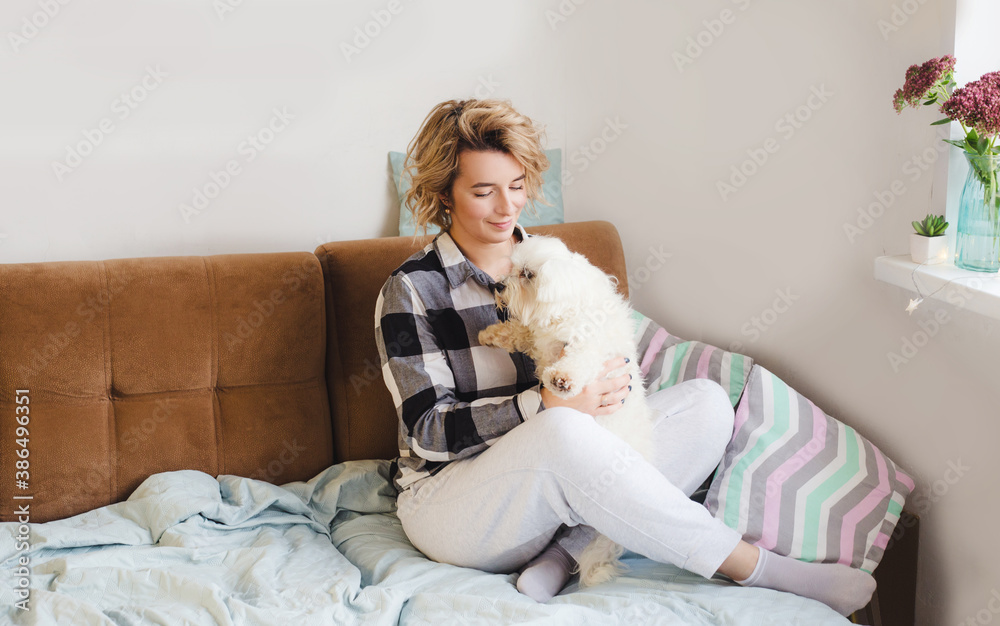 a young girl spends time at home with her beloved dog sitting on a cozy sofa a young girl spends time at home with her beloved dog sitting on a cozy sofa
