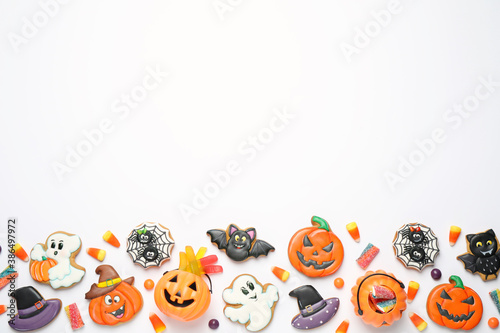 Tasty cookies and sweets for Halloween party on white table, flat lay. Space for text