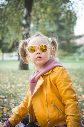 portrait of a little beautiful three-year-old girl who plays outdoor