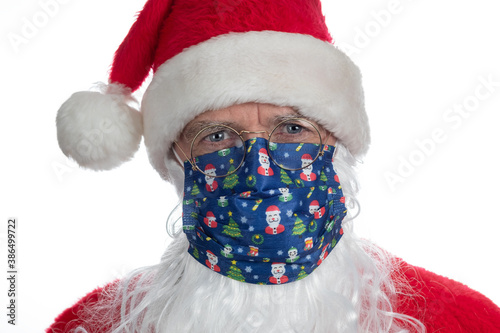 Head shot of Santa wearing a Covid 19 face mask isolated on a white background