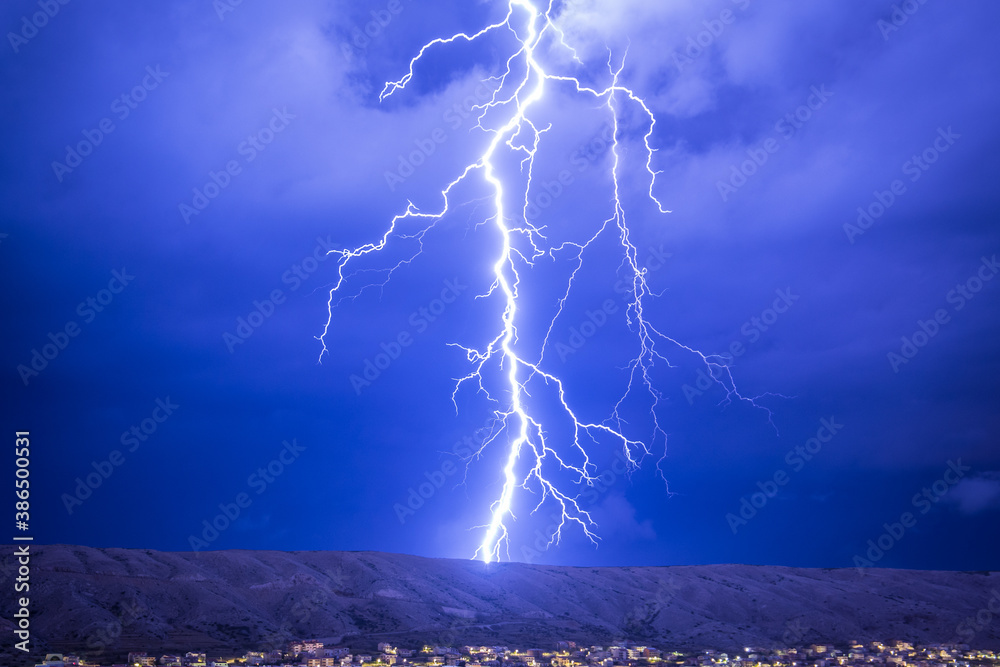 Huge and strong lightning strike at night during a severe thunderstorm - obrazy, fototapety, plakaty 