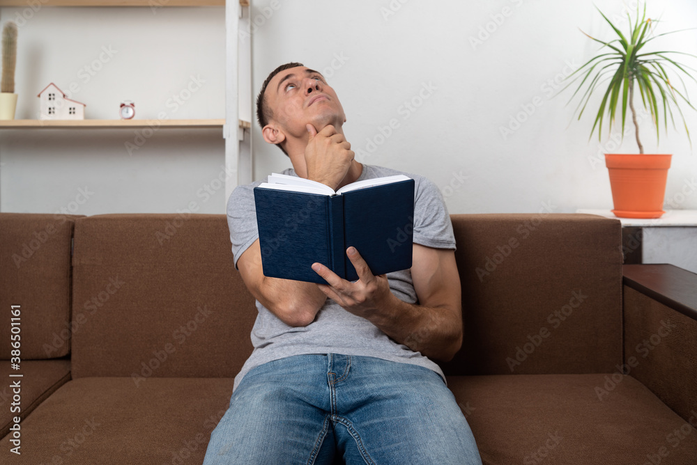 Obraz premium Man reads the Bible and looks up thoughtfully. Search for God