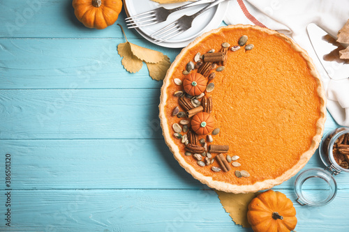 Delicious homemade pumpkin pie on light blue wooden table, flat lay. Space for text