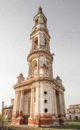 Ruins of a tall bell tower and Russian Orthodox church. Autumn colours, clear sky, no people. © Igor