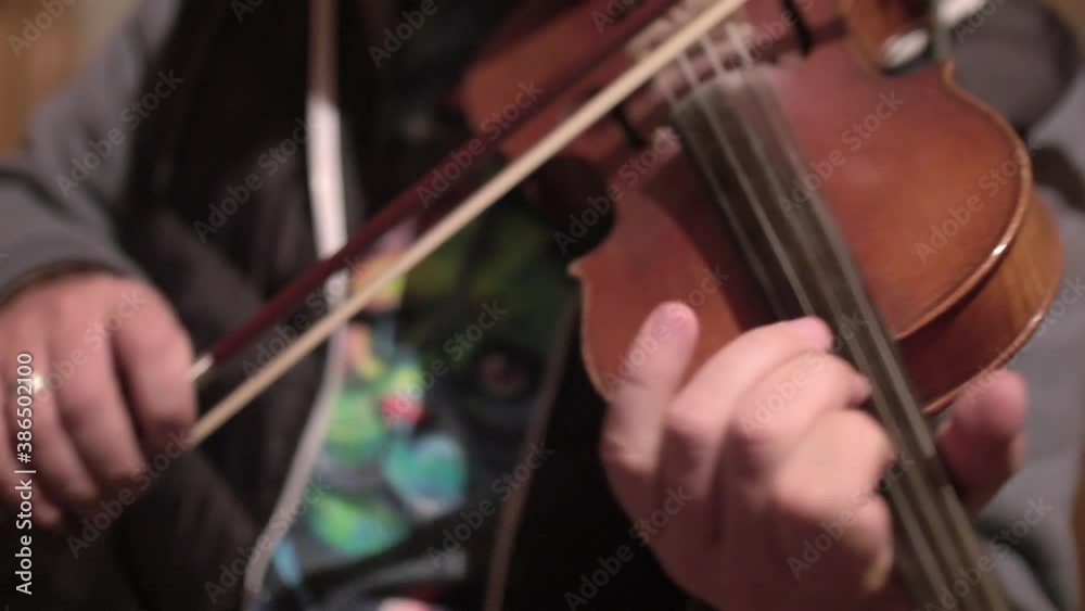 Soft focus and close up of musician playing violin. Beginning of a concert in friendly atmosphere. Soft focus and close up of musician playing violin. Beginning of a concert in friendly atmosphere.