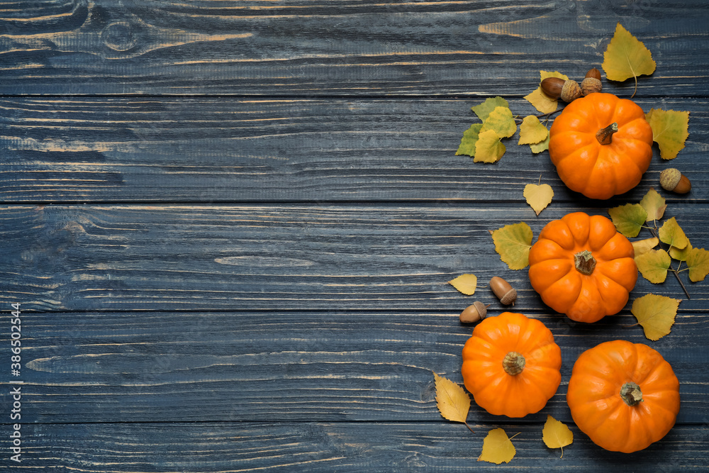 Flat lay composition with pumpkins and autumn leaves on blue wooden table. Space for text Flat lay composition with pumpkins and autumn leaves on blue wooden table. Space for text