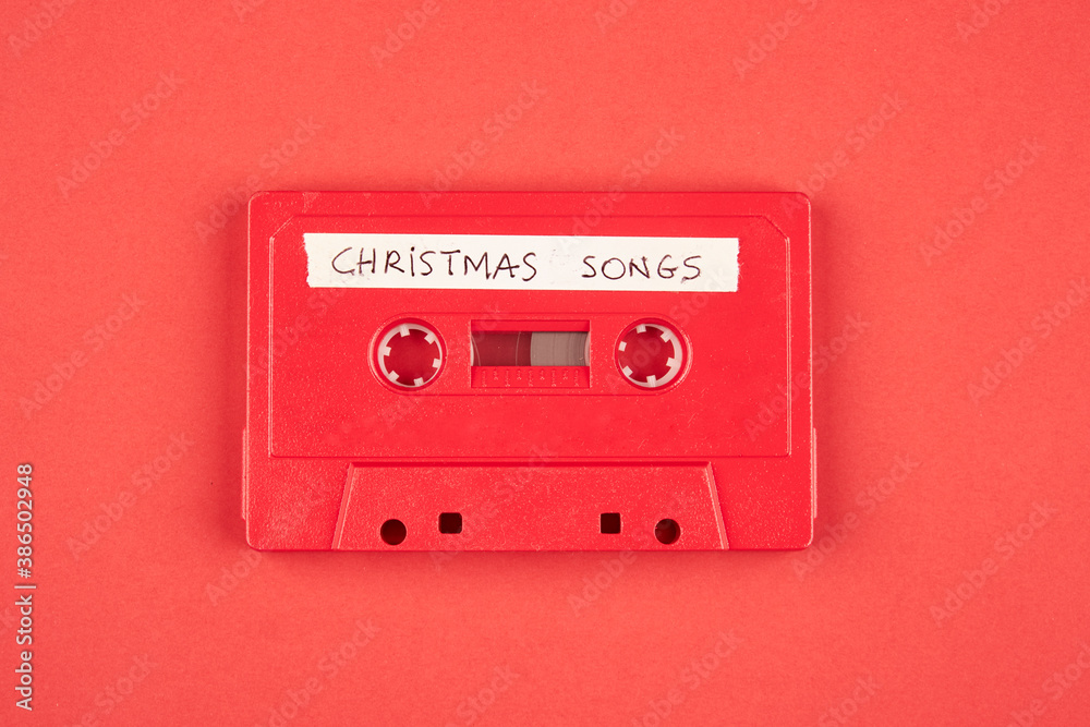 Obraz premium Audio cassette tape with christmas songs on a red background