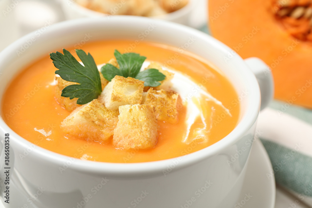 Delicious pumpkin soup in bowl on table, closeup Delicious pumpkin soup in bowl on table, closeup