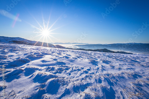 Crystal clear blue winter sky with sunshine and snowy landscape in Austria