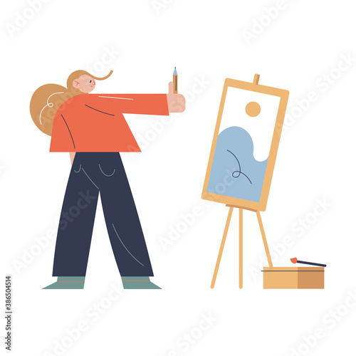 Woman standing opposite easel and drawing scenery picture with pansil in art studio