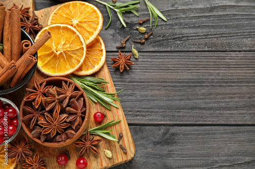 Flat lay composition with mulled wine ingredients on black wooden table. Space for text