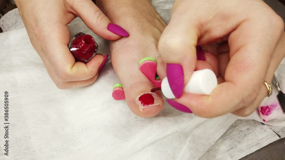 Close-up of female feet painting red nail polish, self made pedicure at home. Close-up of female feet painting red nail polish, self made pedicure at home.