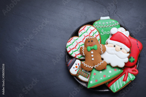 Delicious gingerbread Christmas cookies on black table, top view. Space for text