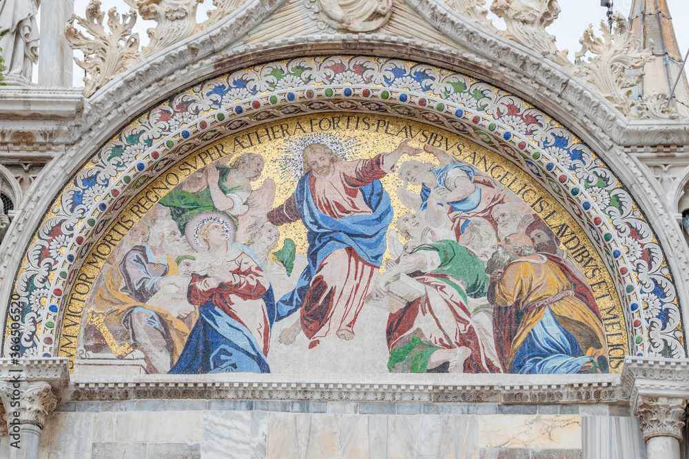 Banner with ancient mosaic at main facade of Basilica San Marco depicting Biblical scene in Venice, Italy, closeup, details.