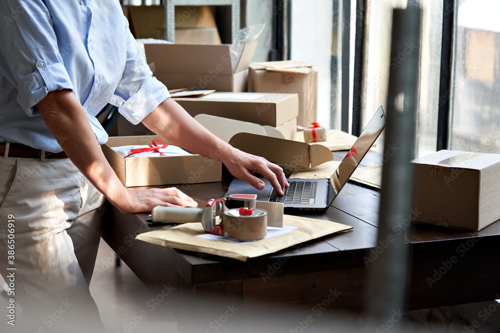 © insta_photos - Female online store small business owner entrepreneur seller packing shipping ecommerce box checking website retail order using laptop preparing delivery parcel on table. Dropshipping concept. Closeup © insta_photos - Female online store small business owner entrepreneur seller packing shipping ecommerce box checking website retail order using laptop preparing delivery parcel on table. Dropshipping concept. Closeup