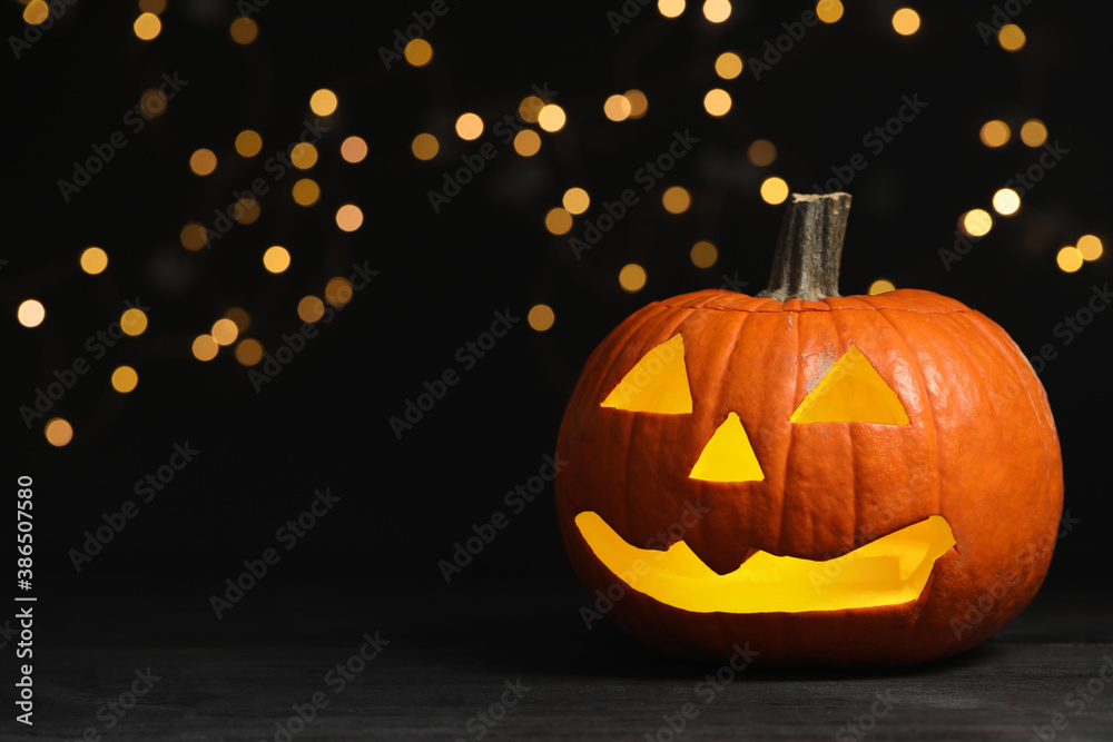 Fototapeta premium Pumpkin jack o'lantern on table against blurred background, space for text. Halloween decor