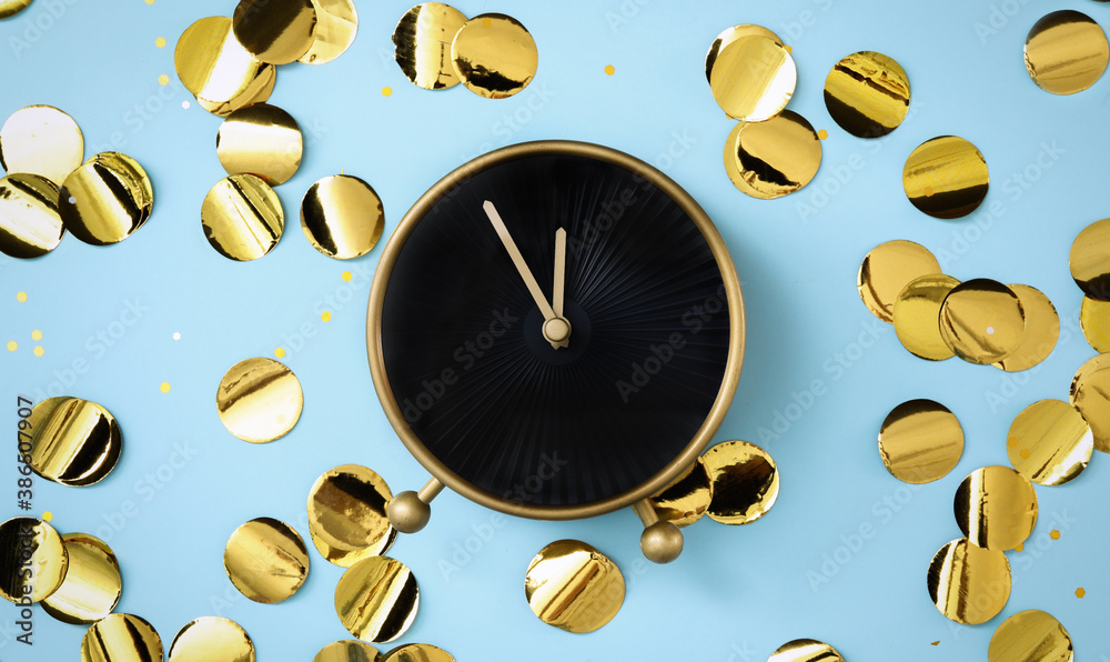 Alarm clock and golden confetti on light blue background, flat lay. New Year countdown - obrazy, fototapety, plakaty 