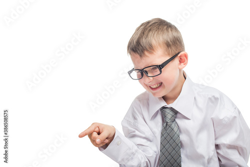 Little cute boy in a shirt and a tie points a finger forward and yells. Angry young businessman is screaming