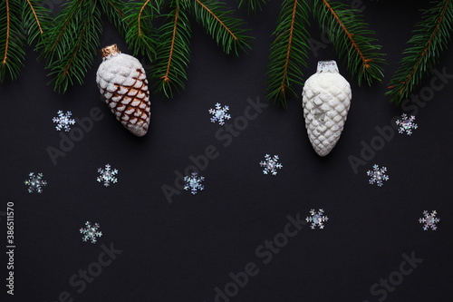 Festive and holiday concept. Christmas background with copy space for text. Christmas tree branches, toy cones and snowflakes on dark texture. Christmas gift card. Top view, flat lay photo