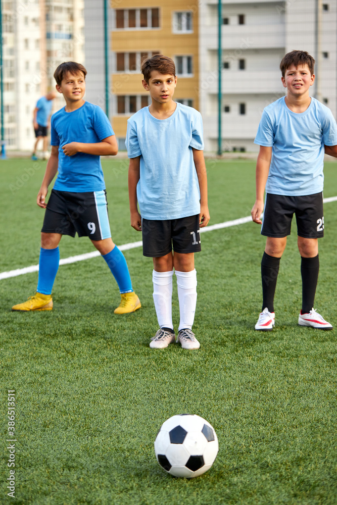 young caucasian footballers on football match in stadium, soccer players running, exercising, on competition