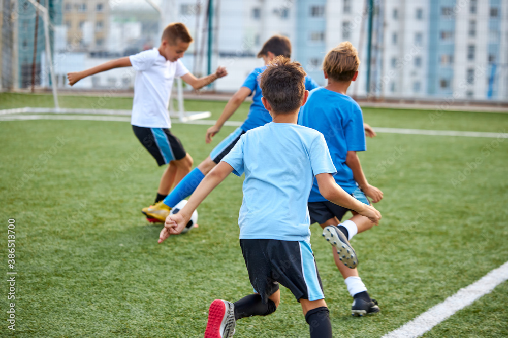 Obraz premium young caucasian footballers on football match in stadium, soccer players running, exercising, on competition