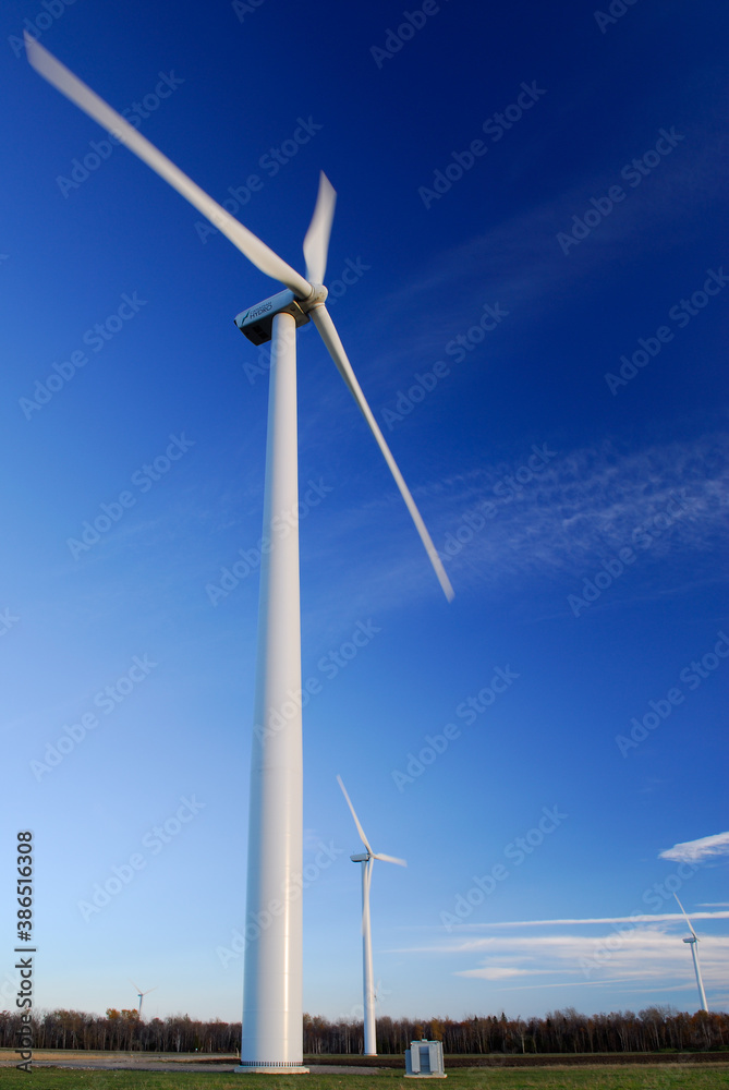 Large spinning Wind turbines against a blue sky